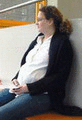 Schwangere Frau sitzt auf der Bank