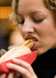 Junge Frau isst Bratwurst